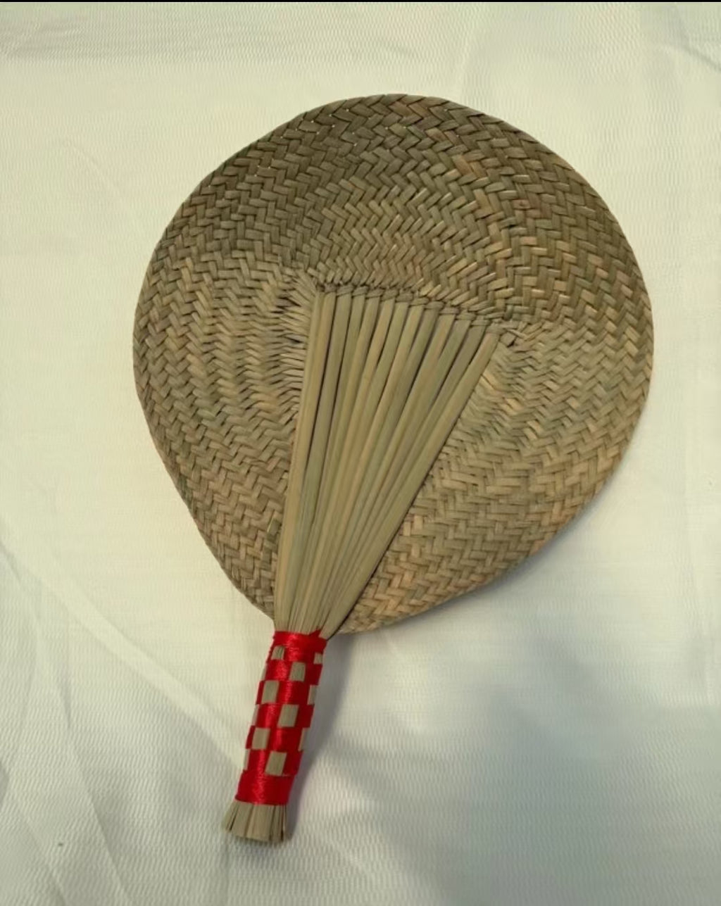 A naturally grown cattail straw fan, hand-woven in a traditional Chinese style. This bamboo fan is an excellent item for keeping cool in the summer, with a retro design and a distinct Chinese aesthetic.